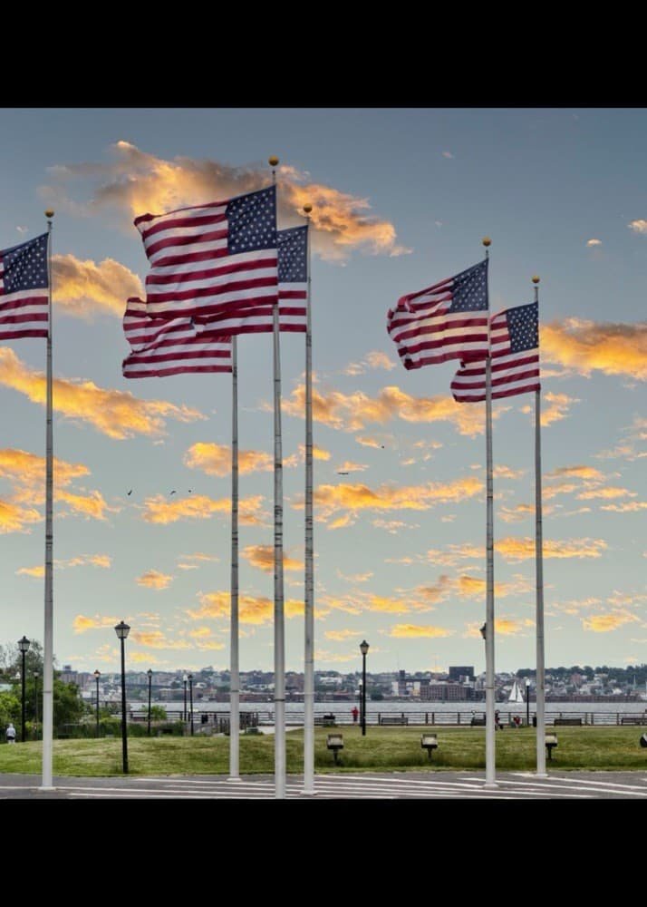 American flags waving with the Statue of Liberty under a sunset sky - online reputation management services across the United States